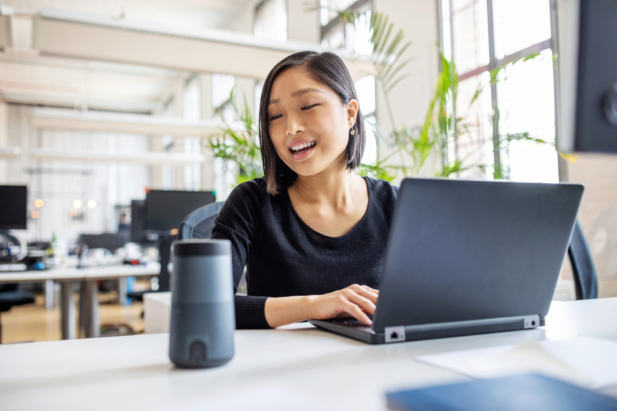 Female professional using virtual assistant at desk