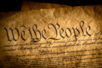 We the People, the beginning of the United States constitution lit by a window light